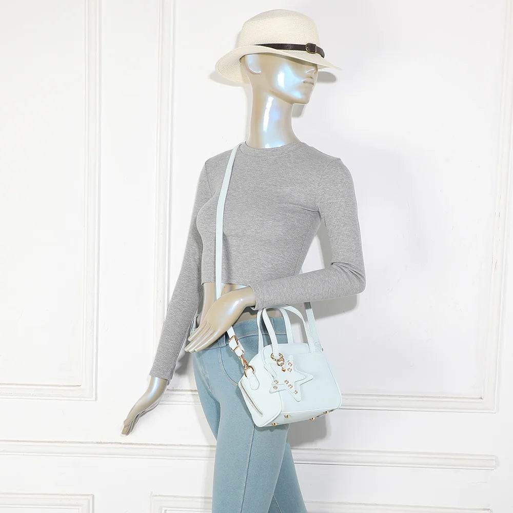 Mini sac La Féerie bleu clair porté par une femme, à la main ou avec sa bandoulière amovible – réf. R-2052