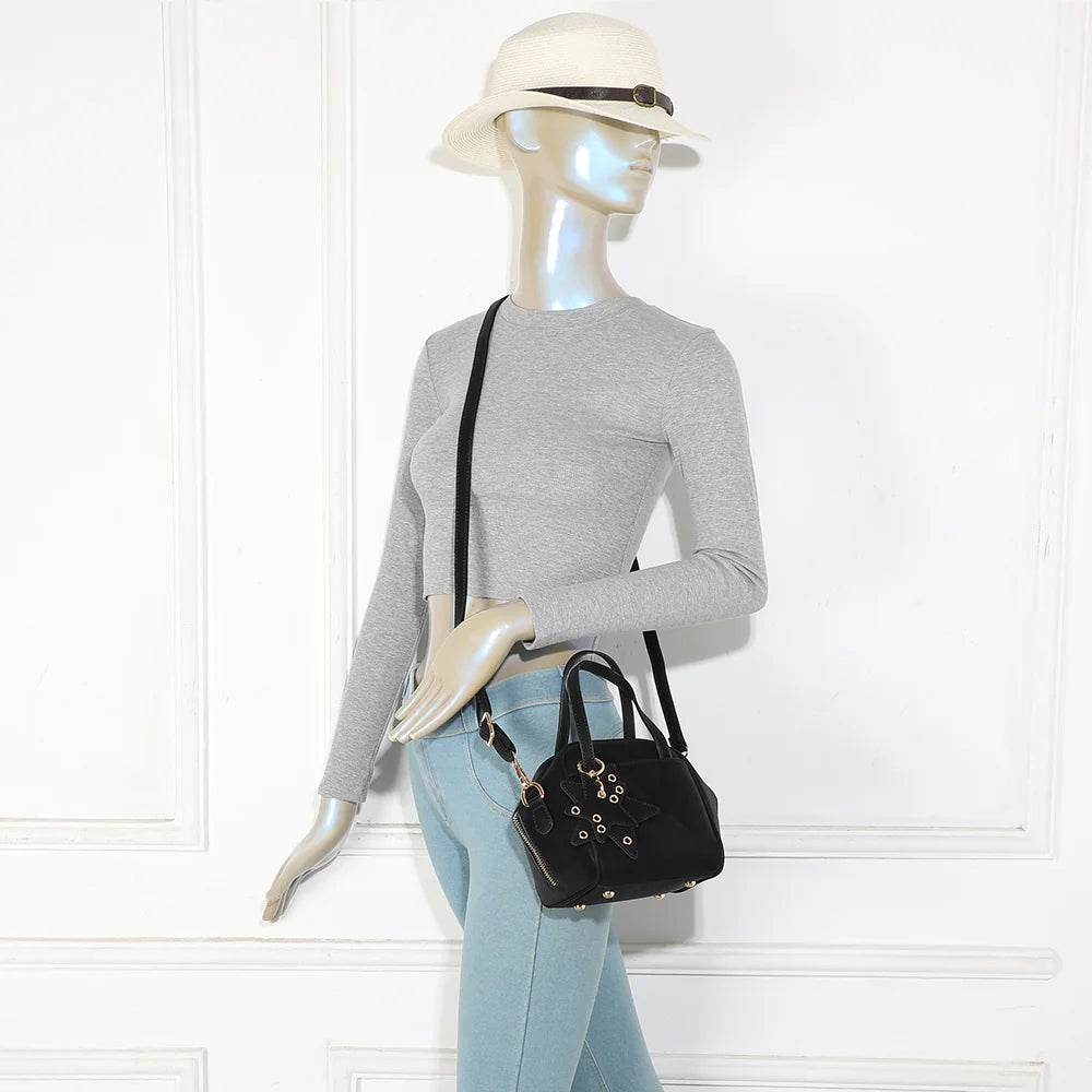 Mini sac La Féerie noir porté par une femme, à la main ou avec sa bandoulière amovible – réf. R-2052
