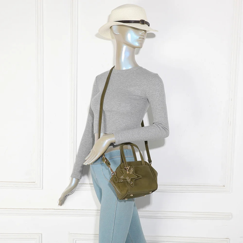 Mini sac La Féerie vert foncé porté par une femme, à la main ou avec sa bandoulière amovible – réf. R-2052