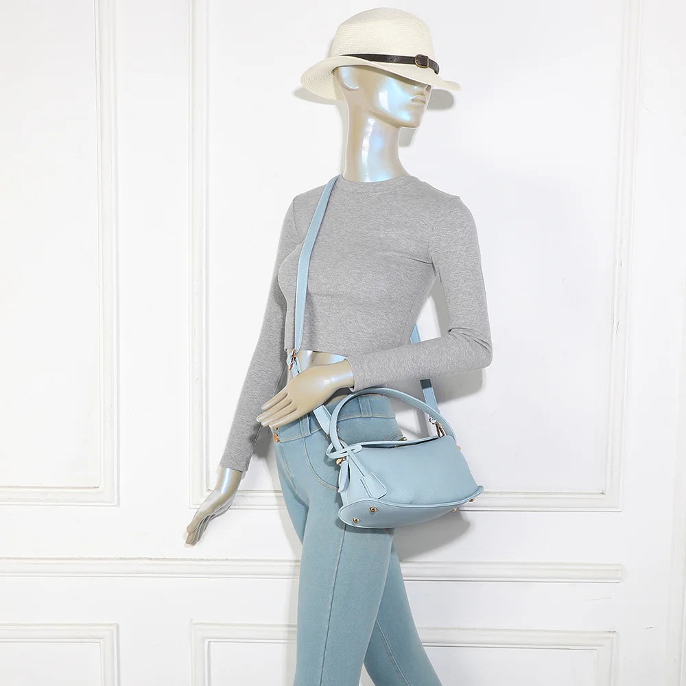 Sac à main La Isée bleu clair porté par une femme, à la main ou en bandoulière – réf. R-2063
