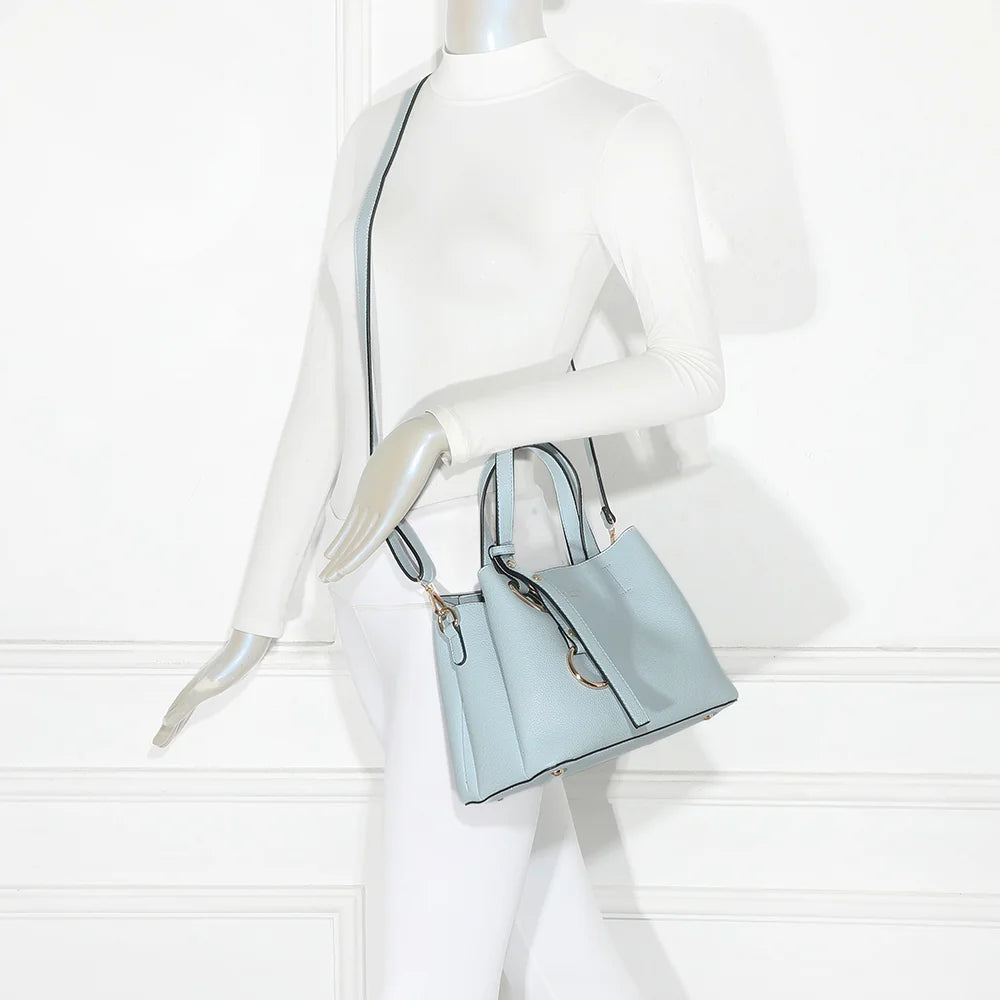Sac à main femme La Moderne bleu clair porté à la main, anses courtes et anneaux dorés – réf. R-1710