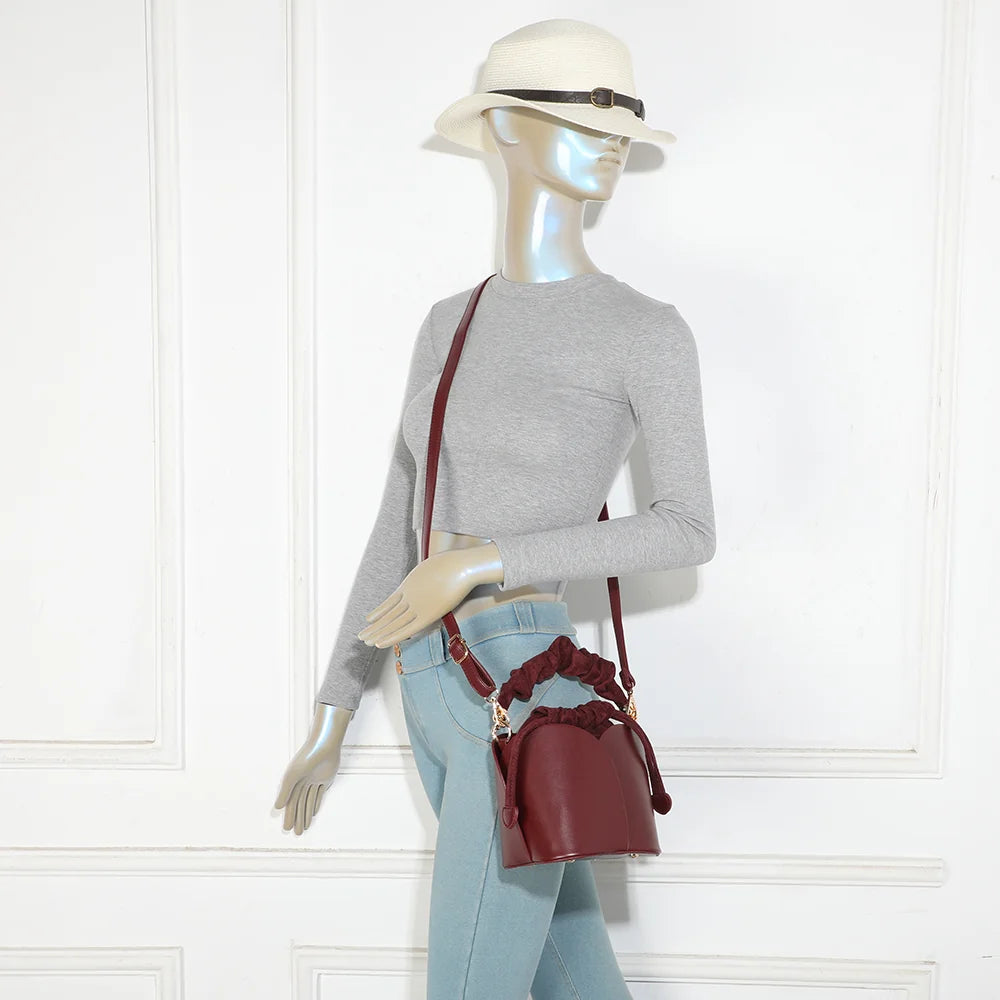 Sac La Nuvia bordeaux porté par une femme, à la main par sa poignée froncée ou en bandoulière – réf. DQ-8727