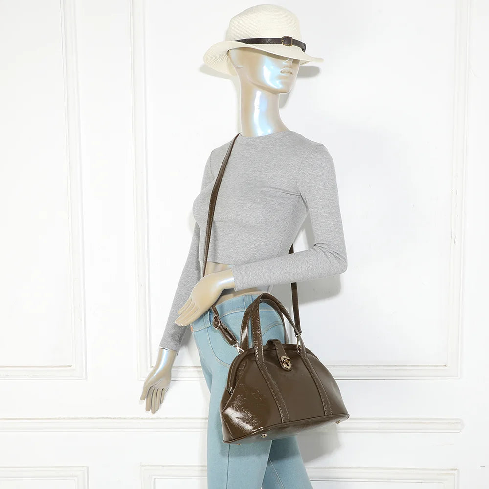 Sac La Parure vert foncé porté par une femme, tenu à la main par ses deux anses surpiquées – réf. R-2065