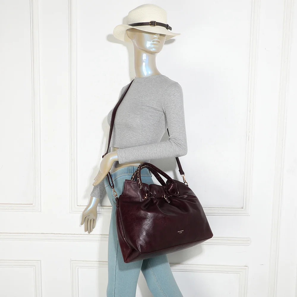 Sac La Régence bordeaux porté par une femme, à la main par ses anses à chaîne ou à l’épaule – réf. JC-53011