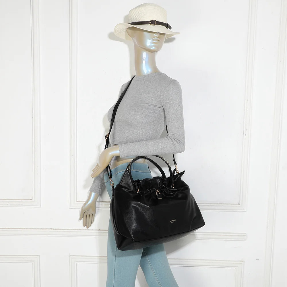 Sac La Régence noir porté par une femme, à la main par ses anses à chaîne ou à l’épaule – réf. JC-53011