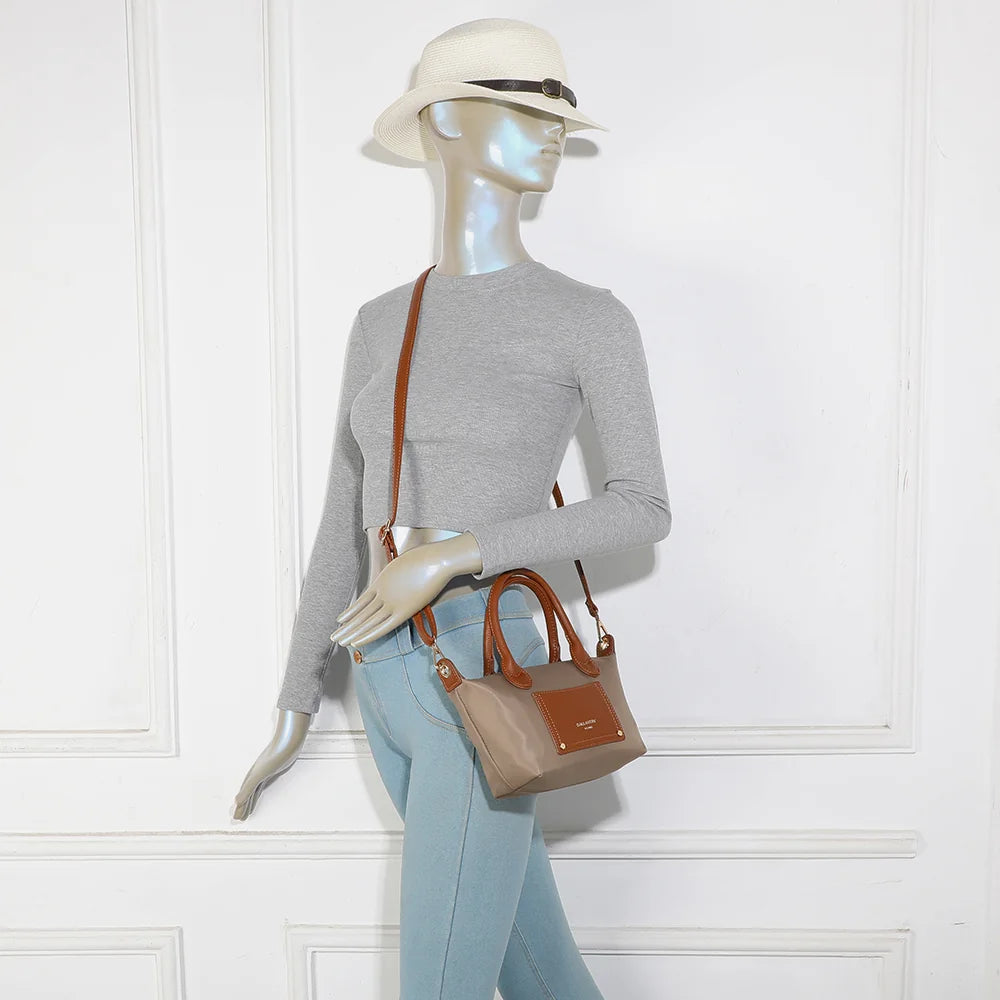 La Romane taupe foncé portée par une femme, à la main par ses anses cognac ou à l’épaule – réf. Z-05-6