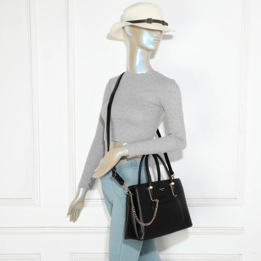 Sac à main La Valdine noir porté par une femme, à la main ou avec sa bandoulière – réf. M-9464