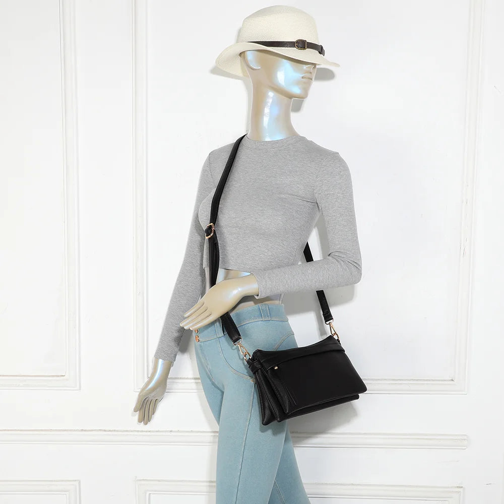 Sac bandoulière La Vélane noir porté en travers du corps par une femme, bandoulière réglable – réf. A-9176
