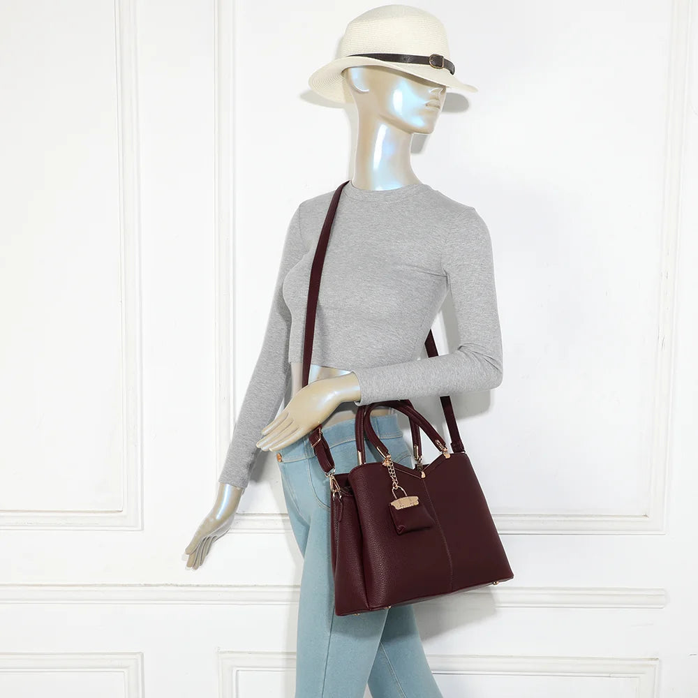 Sac à main femme La Vérone bordeaux porté à la main, charm doré bien visible – réf. M-9130-1