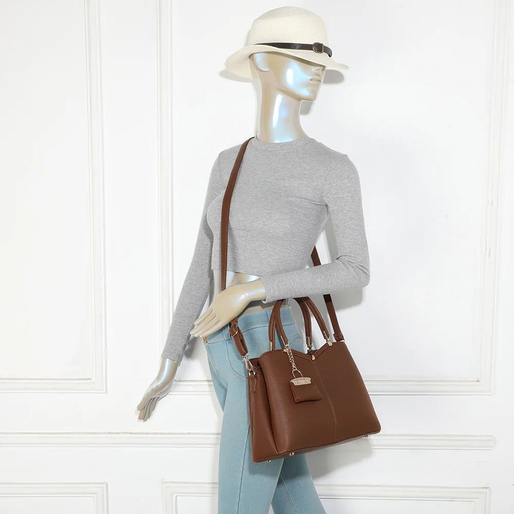 Sac à main femme La Vérone marron foncé porté à la main, charm doré bien visible – réf. M-9130-1