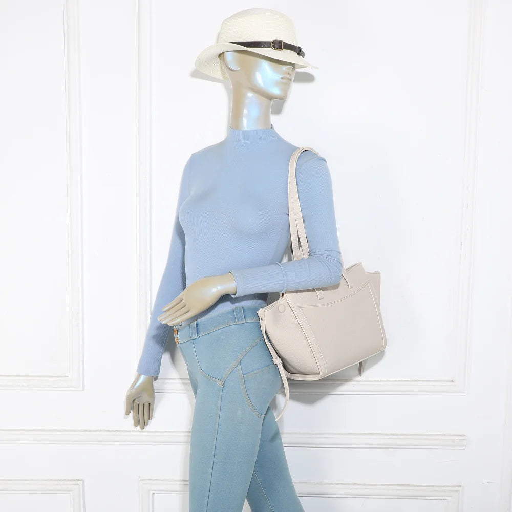 Sac Laguna beige porté par une femme, à l’épaule grâce à ses longues anses de 34 cm – réf. R-2029