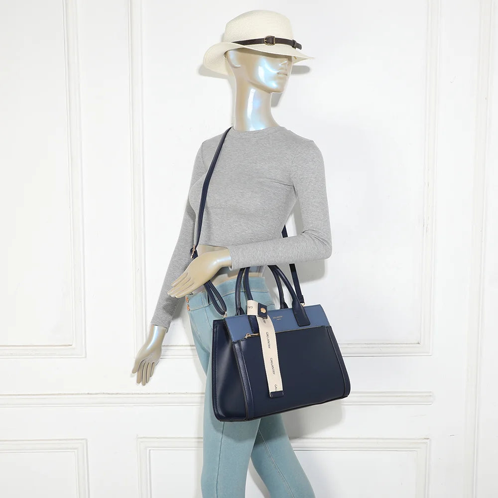 Sac à main Le Berkeley bleu foncé porté par une femme, à la main ou avec sa bandoulière – réf. LS-76003