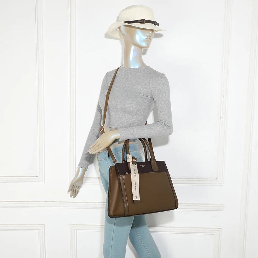 Sac à main Le Berkeley taupe foncé porté par une femme, à la main ou avec sa bandoulière – réf. LS-76003