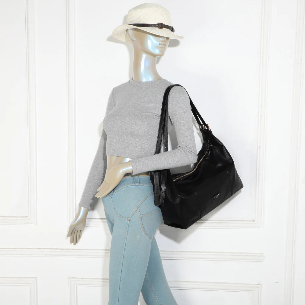 Sac Le Brumaire noir porté à l’épaule par une femme, anses ajustées par boucles dorées – réf. JC-53012