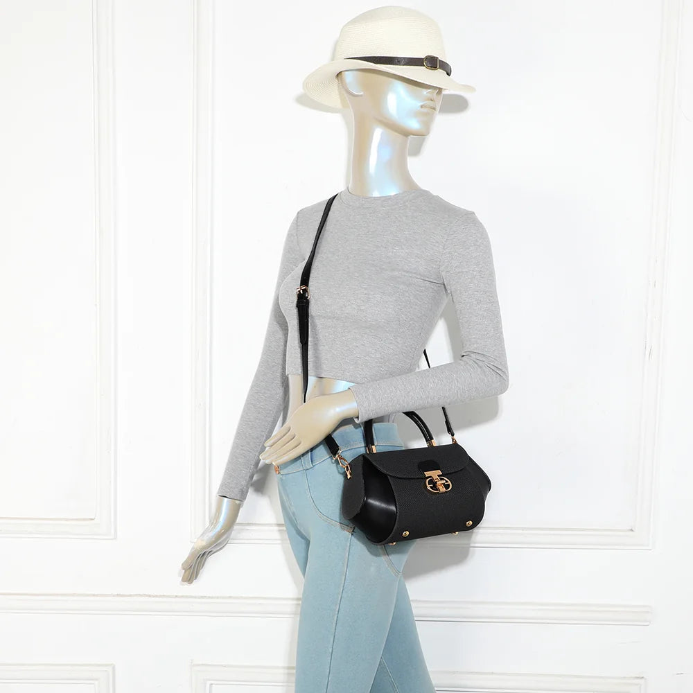 Le Calvia noir porté par une femme à la main grâce à sa poignée rigide, format compact et chic – réf. YL-26008-2