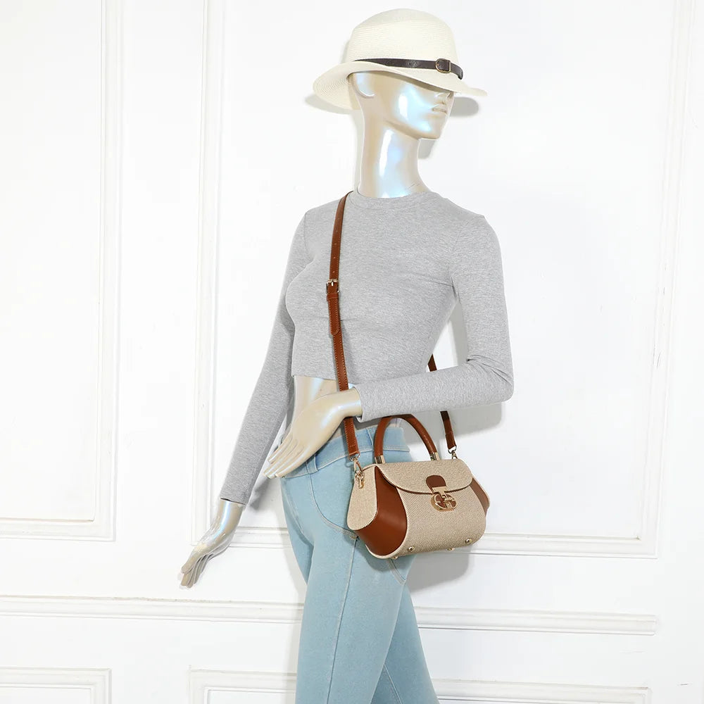 Le Calvia taupe/marron porté par une femme à la main grâce à sa poignée rigide, format compact et chic – réf. YL-26008-2