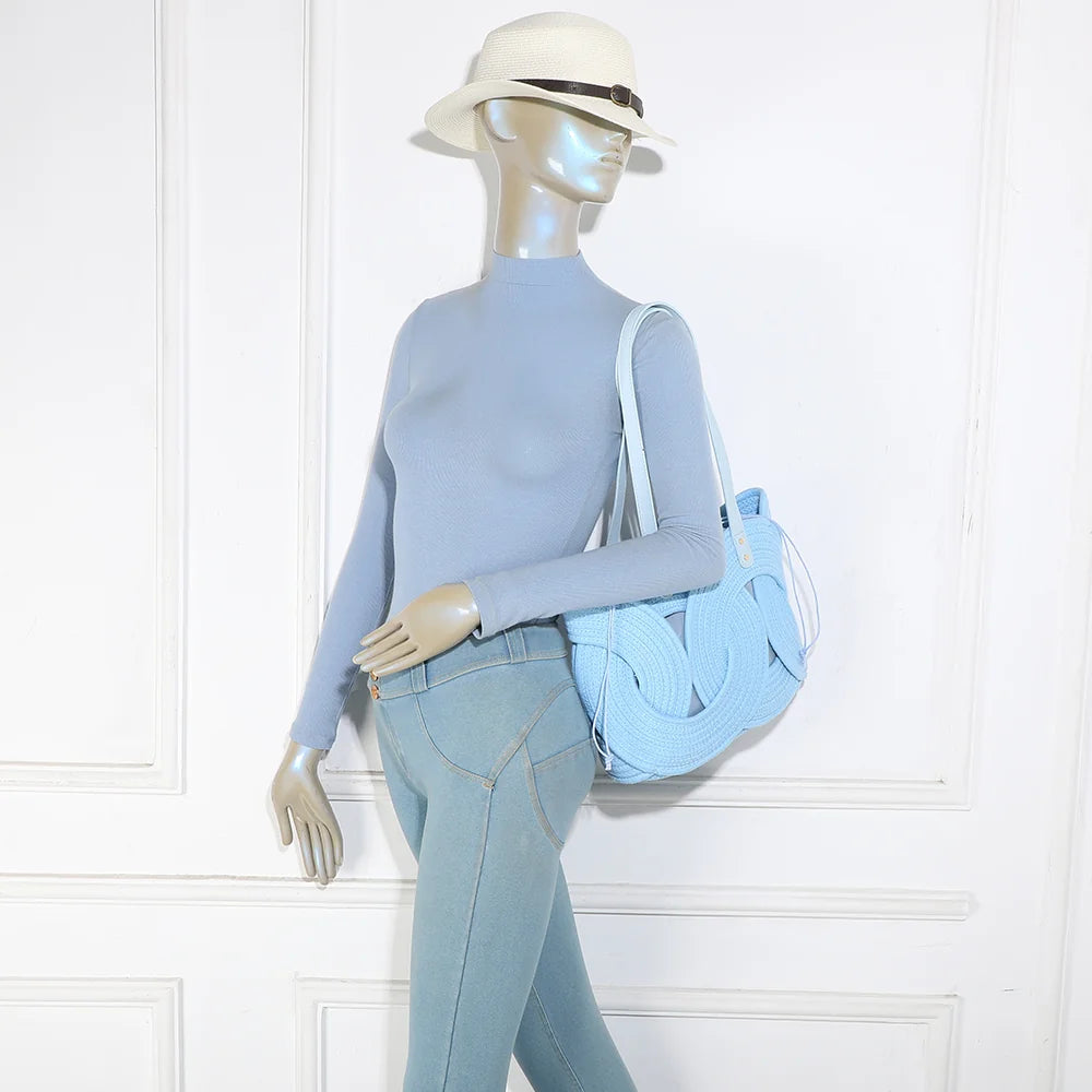 Le Candyloop bleu clair porté à l’épaule par une femme : longues anses et motif tressé mis en valeur – réf. A-9168