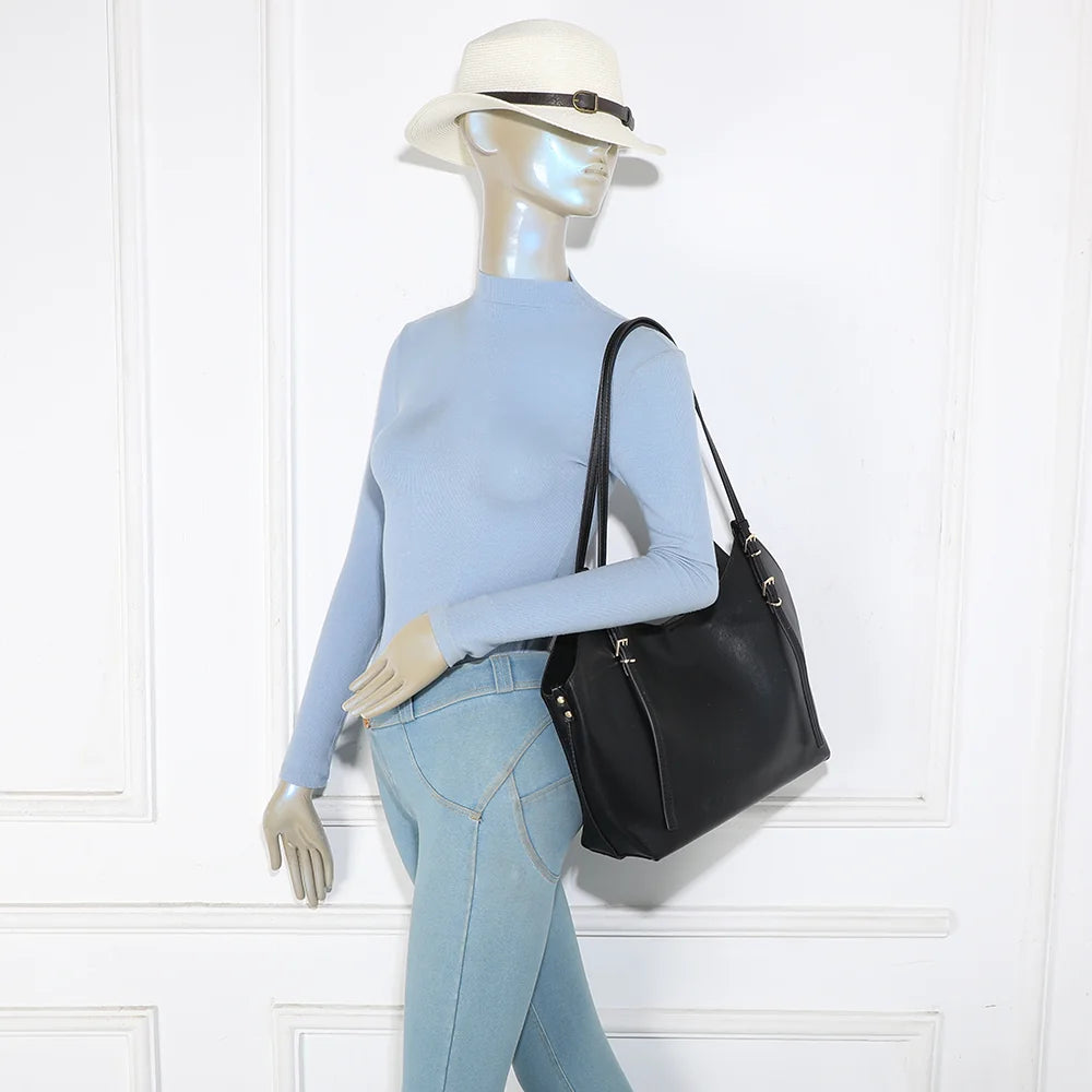 Sac cabas Élance noir porté à l’épaule par une femme grâce à ses longues anses – réf. A-8721-1