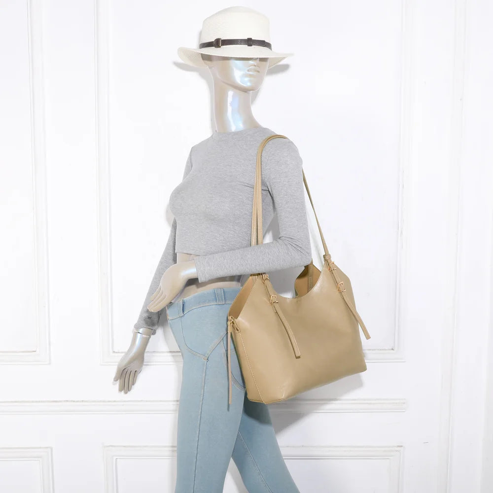 Sac cabas Élance taupe porté à l’épaule par une femme grâce à ses longues anses – réf. A-8721-1