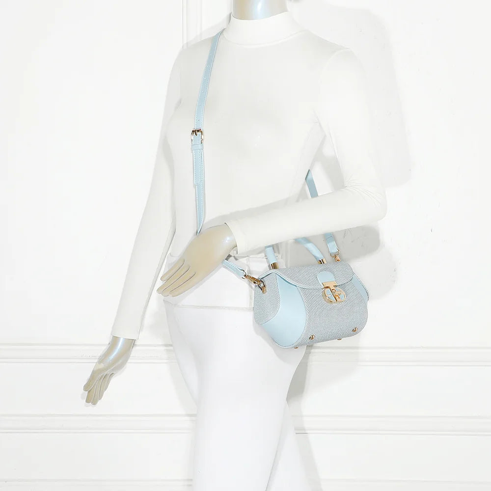 Mini sac Le Léa bleu clair porté par une femme, à la main ou en bandoulière avec sa sangle amovible – réf. YL-26008