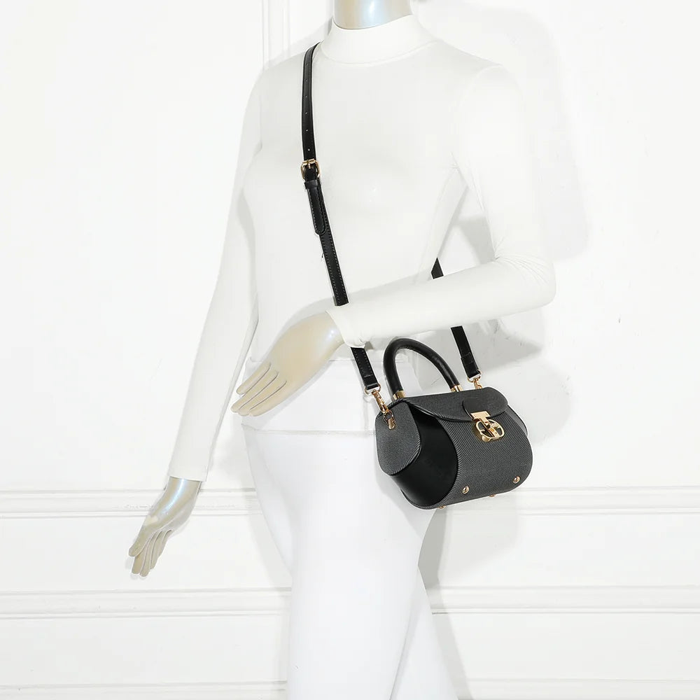 Mini sac Le Léa noir porté par une femme, à la main ou en bandoulière avec sa sangle amovible – réf. YL-26008