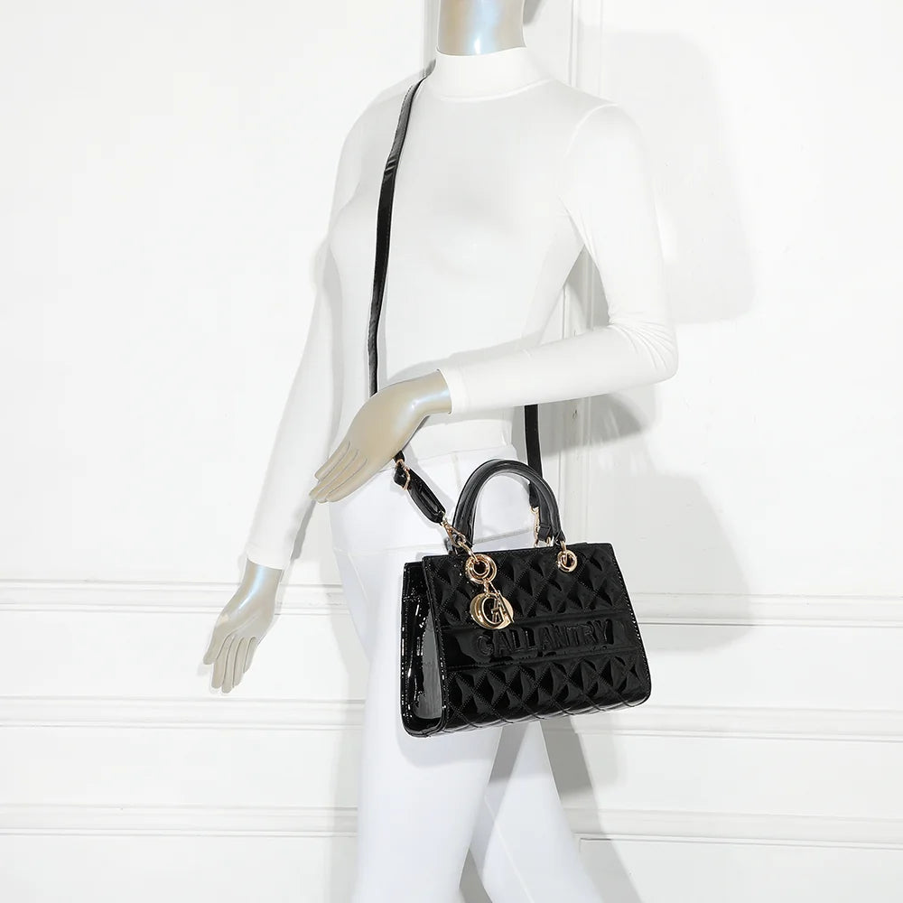 Le Matelassé Chic noir porté par une femme, à la main ou en bandoulière avec sa sangle amovible – réf. C-0169-1