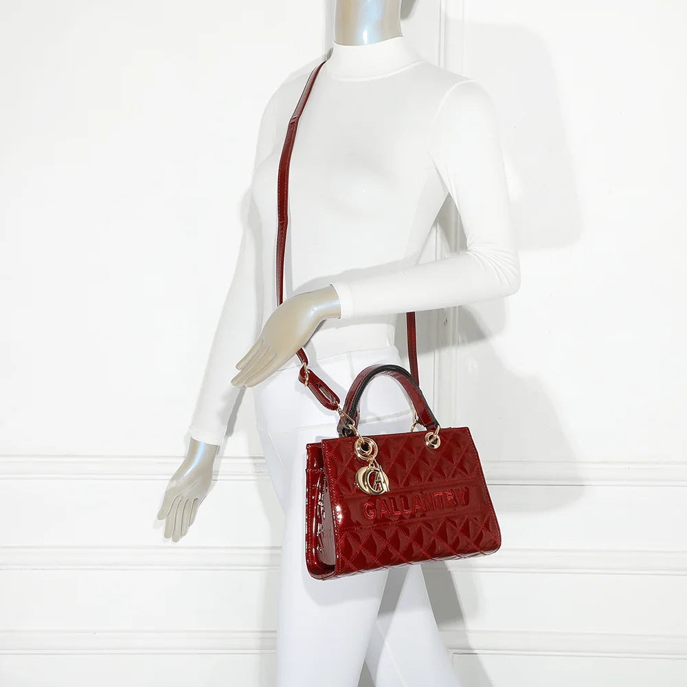 Le Matelassé Chic rouge foncé porté par une femme, à la main ou en bandoulière avec sa sangle amovible – réf. C-0169-1