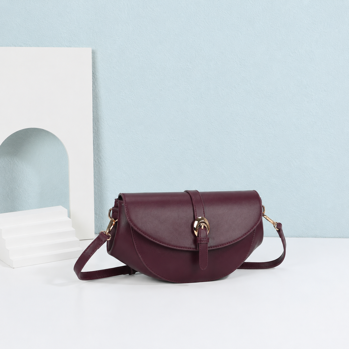 Sac à main Le Merlot bordeaux à boucle dorée dans une mise en scène – visuel d’ambiance créé avec l’IA – Gallantry Paris