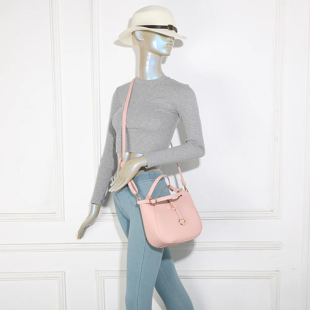 Le Nolan rose porté par une femme, sac compact à poignée réglable et bandoulière amovible – réf. KJ-62098