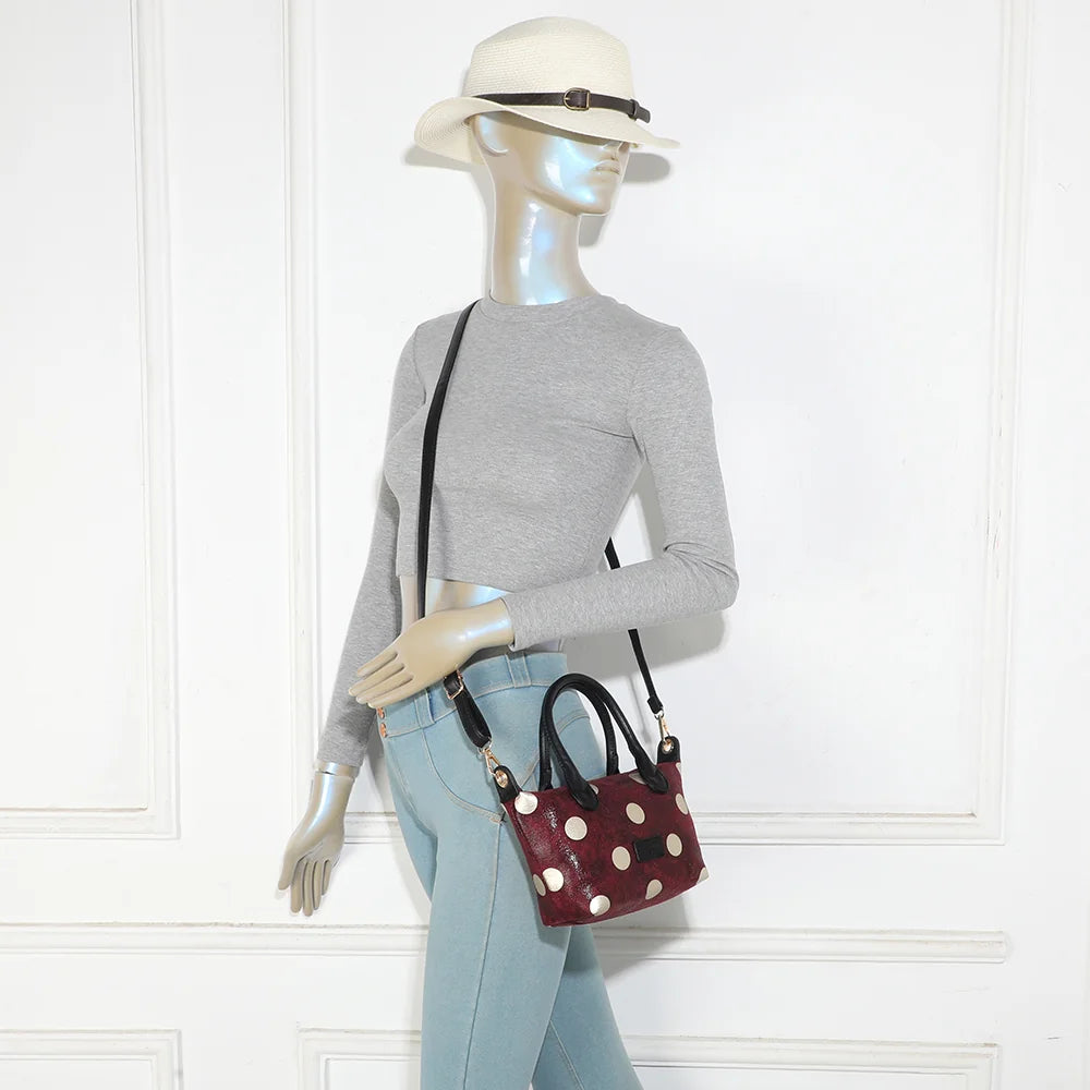 Petit sac à main Le Polka bordeaux porté par une femme, à la main ou avec sa bandoulière amovible – réf. Z-05-10