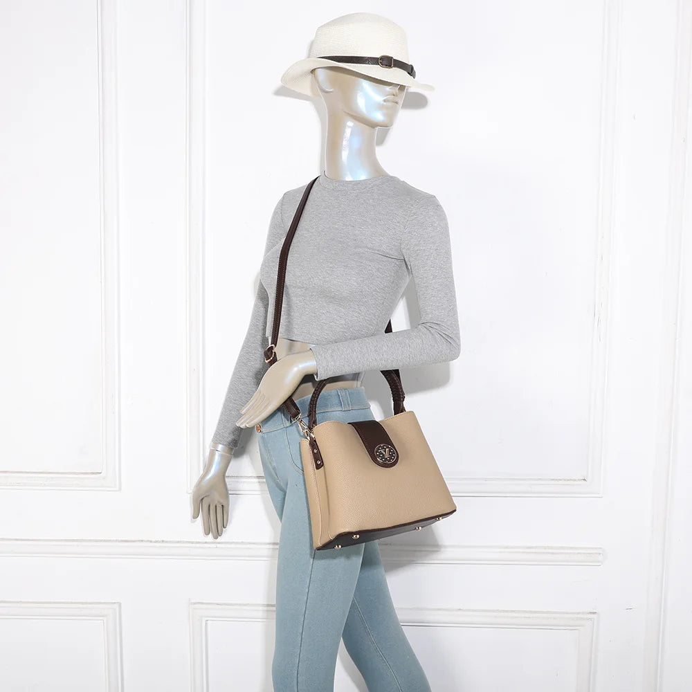 Le Solvane taupe/coffee porté par une femme, à la main ou à l’épaule grâce à sa bandoulière amovible