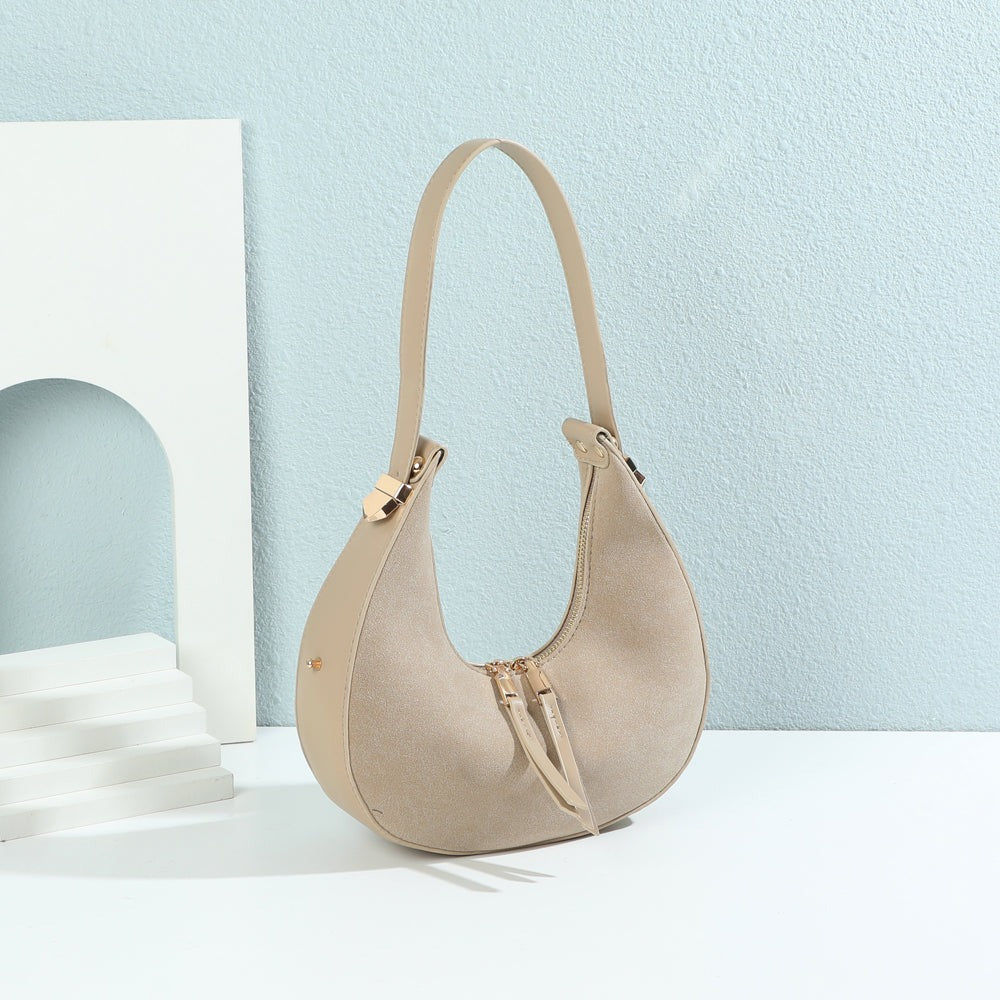 Sac à main demi-lune Luméra taupe en suédine mis en scène dans un décor – visuel d’ambiance créé avec l’IA – Gallantry Paris