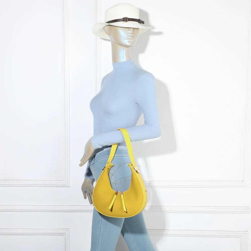 Sac Luméra jaune porté épaule par une femme : format compact qui se cale sous le bras – réf. A-9151