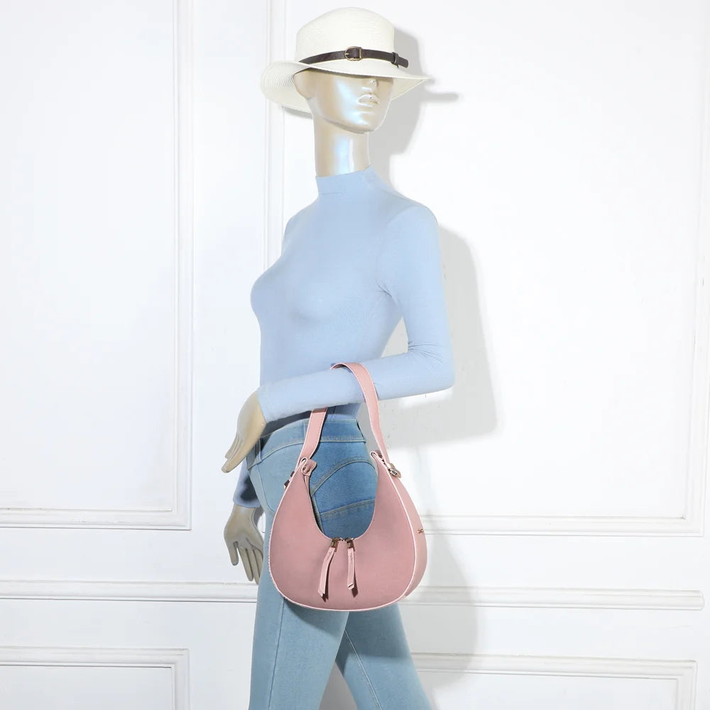 Sac Luméra rose porté épaule par une femme : format compact qui se cale sous le bras – réf. A-9151