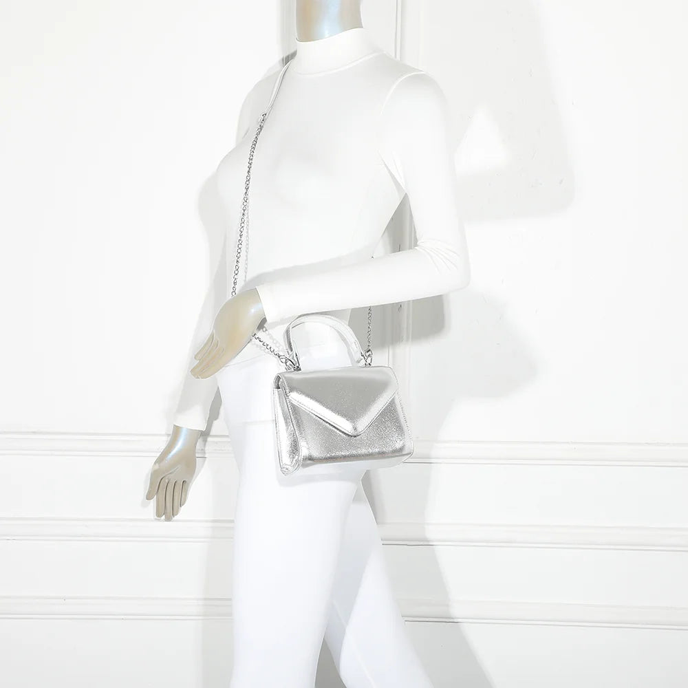 Mini sac Luna argent porté par une femme, pour une touche de brillance sur une tenue de ville ou de soirée – réf. R-1916
