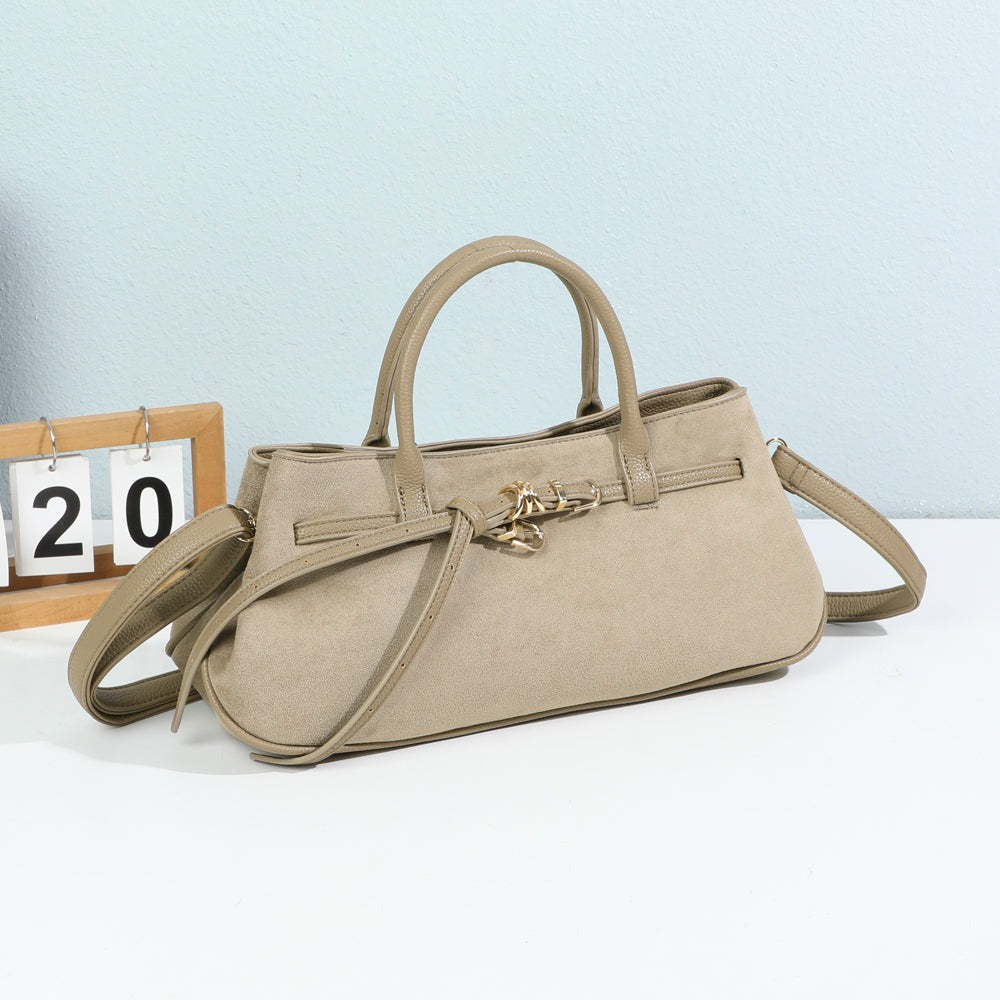 Sac à main Lunéa taupe foncé posé dans un décor, lien à boucles dorées – visuel d’ambiance créé avec l’IA – Gallantry Paris