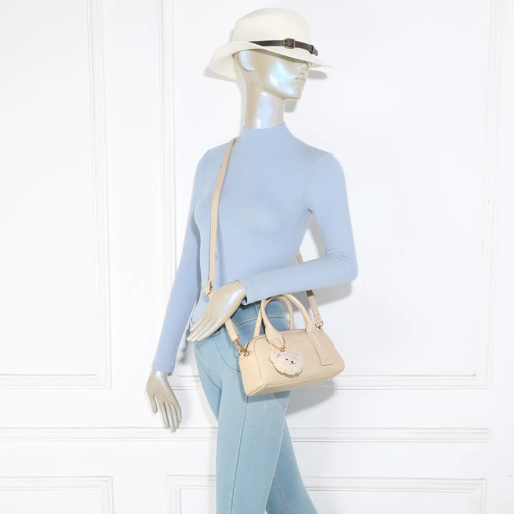 Sac à main femme Lya beige porté, format compact à tenir à la main ou en bandoulière – réf. KJ-62067