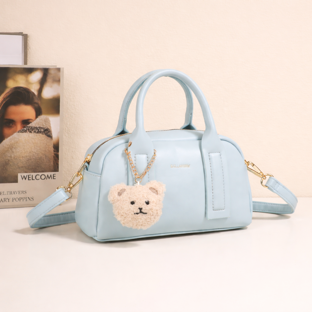 Sac à main bowling Lya Bleu Clair et son porte-clés ourson mis en scène – visuel d’ambiance créé avec l’IA – Gallantry Paris
