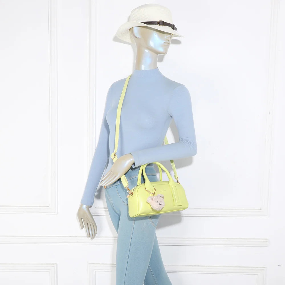 Sac à main femme Lya jaune porté, format compact à tenir à la main ou en bandoulière – réf. KJ-62067