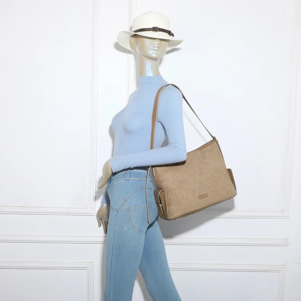 Sac Lyséa taupe foncé porté à l’épaule par une femme, anse longue et confortable – réf. R-2020