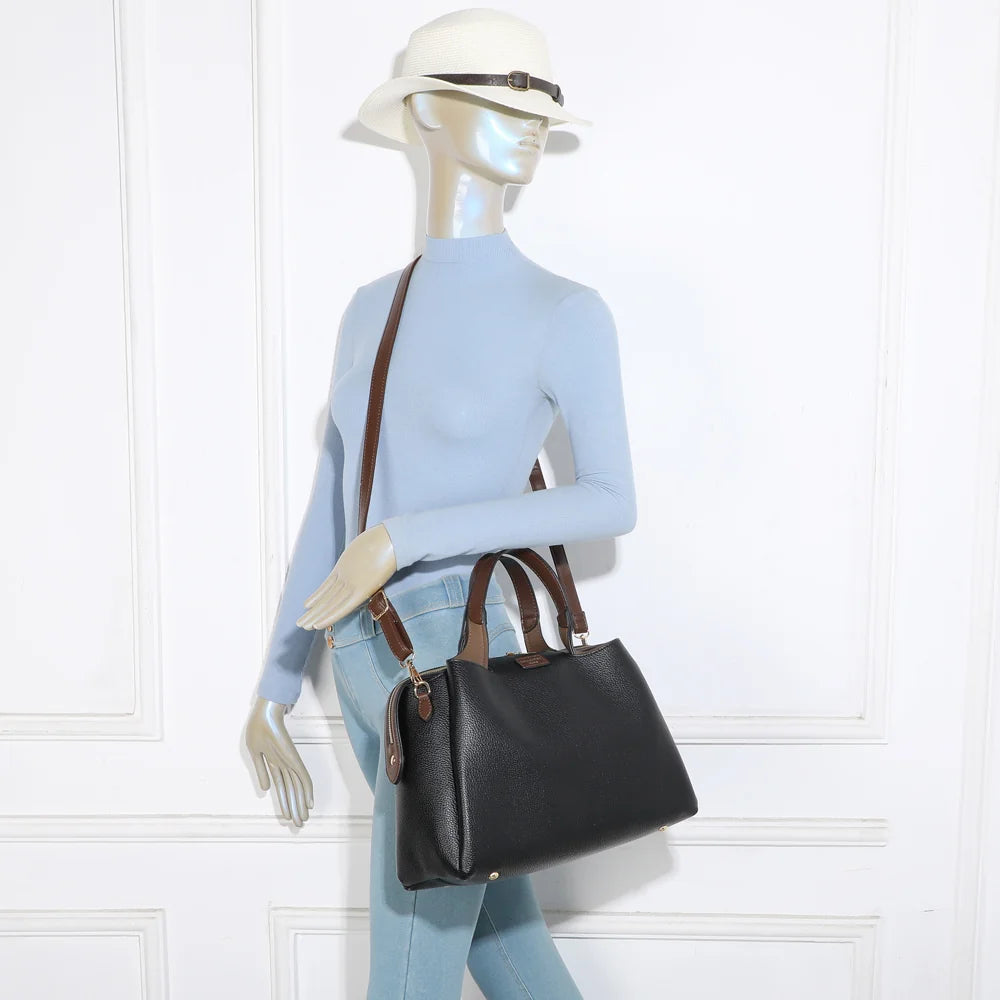 Sac Madison Chic noir porté par une femme, à la main ou avec sa bandoulière marron amovible – réf. M-9458