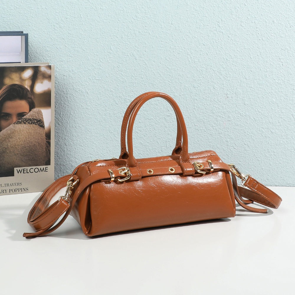 Sac à main Maïa marron posé sur une table blanche devant un mur bleu clair et un magazine – visuel d'ambiance créé avec l'IA – Gallantry Paris