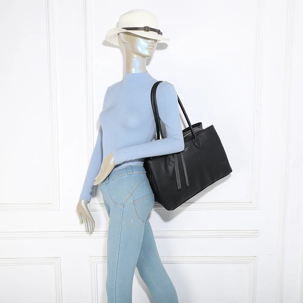 Sac Majestia noir porté à l’épaule par une femme grâce à ses deux longues anses de 29 cm – réf. M-9460-1