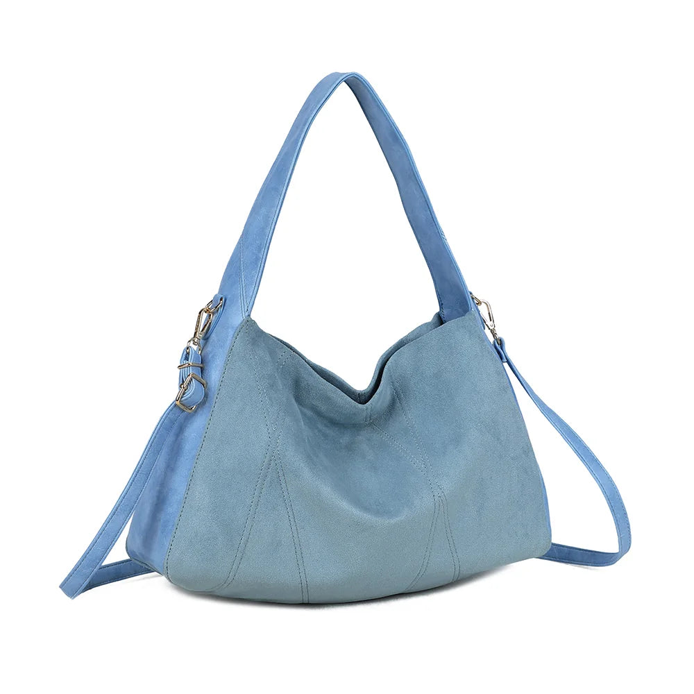Milano bleu clair de trois quarts : forme souple hobo et côtés lisses contrastant avec la façade suédée – réf. HS-43002