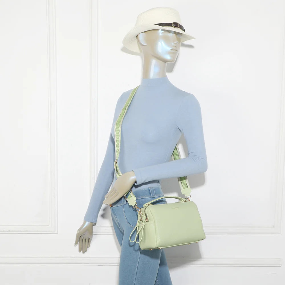 Mini Boston Élégance vert clair porté par une femme, en bandoulière avec sa sangle tissée ajustable – réf. KJ-62060