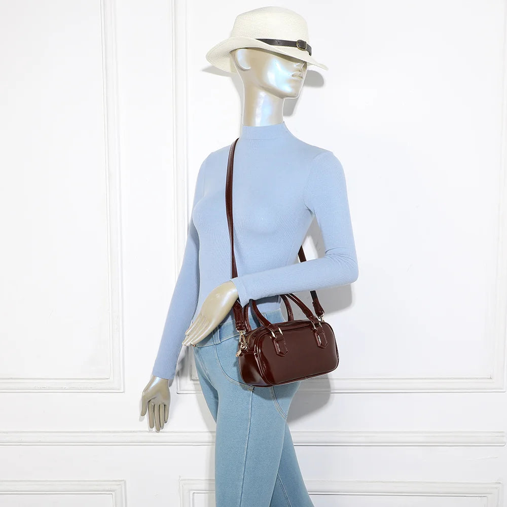 Mini Glossy bordeaux porté par une femme, à la main ou en bandoulière grâce à sa sangle amovible – réf. A-9126
