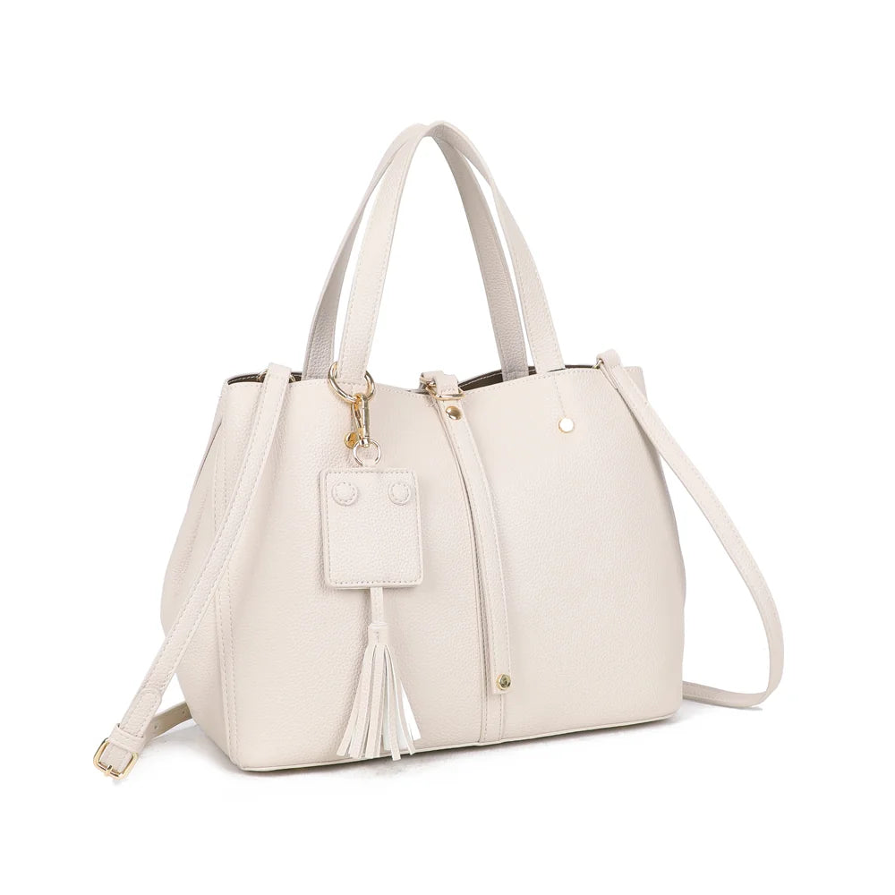 Mirage beige de trois quarts : silhouette structurée, patte verticale à rivets dorés et charm à pompon – réf. DG-5814