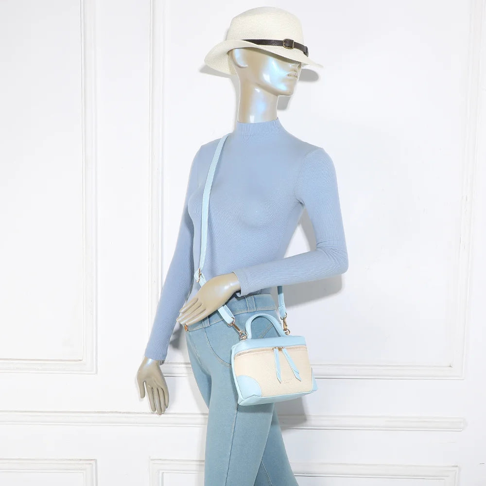 Sac Moka bleu clair porté par une femme, à la main ou en bandoulière grâce à sa sangle amovible – réf. KJ-62091