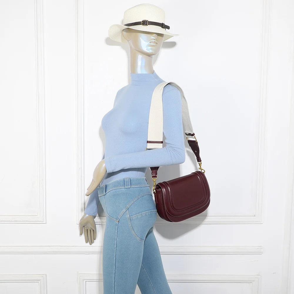 Sac Nova Loop bordeaux porté par une femme, bandoulière large en tissu à l’épaule