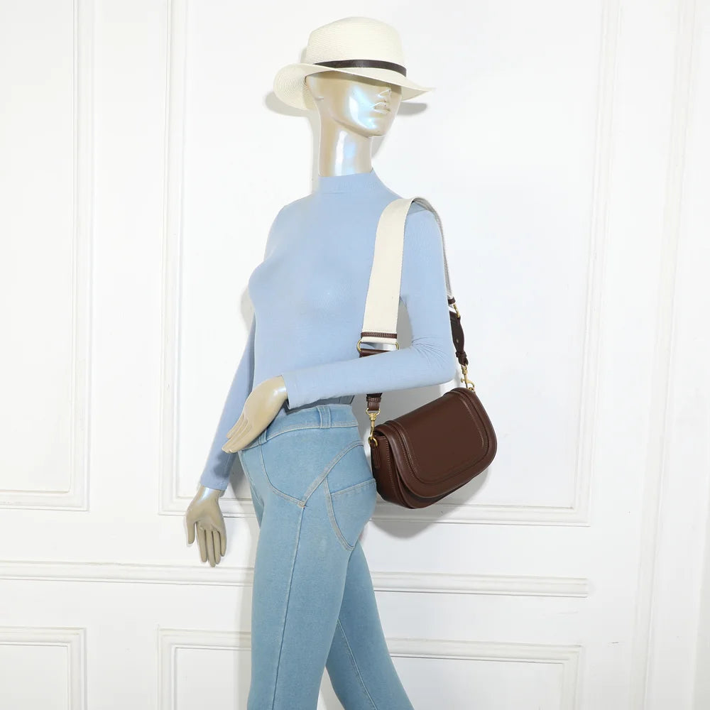 Sac Nova Loop café porté par une femme, bandoulière large en tissu à l’épaule